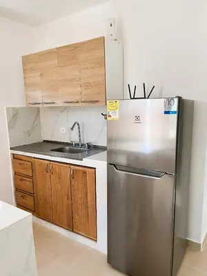 a kitchen with a stainless steel refrigerator and wooden cabinets at Escapate a Tolú - Lindo Apartamento in Santiago