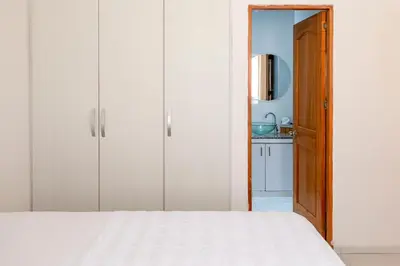 a bedroom with white cabinets and a white bed at edificio Alba in Cartagena de Indias