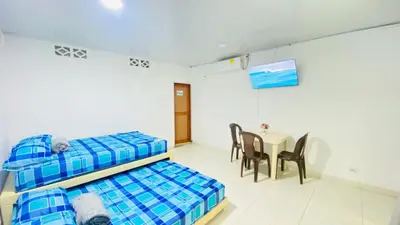 a room with two beds and a table with chairs at Mayo Habitación Tolu in Tolú