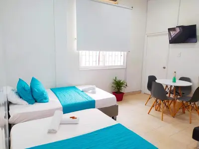 a room with two beds and a table and a tv at apto centro comodo 3 piso -- 1 in Cartagena de Indias