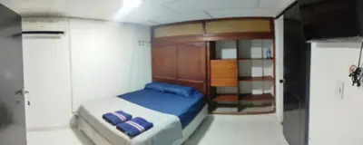 a small bedroom with a bed with blue sheets at casa perla del mar in Cartagena de Indias