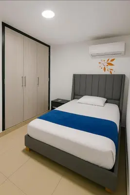 a bedroom with a large bed and a cabinet at Apartamentos CP in Barranquilla
