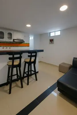 a living room with a table and two stools at Apartamentos CP in Barranquilla