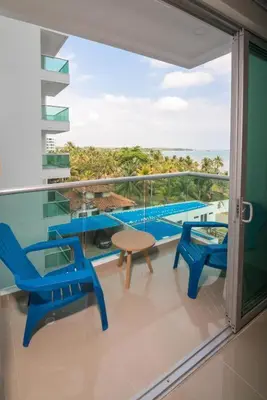 a balcony with chairs and a table and a pool at Magico Apartamento Frente al Mar 3 Habitaciones AR42 in Coveñas