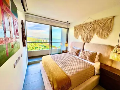 a bedroom with a bed and a large window at Hermoso apartamento con vista al mar in Santa Marta