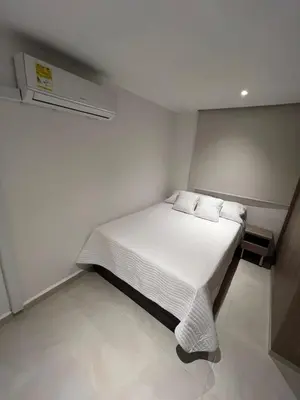 a bedroom with a white bed with white sheets and pillows at Manglar - Ciudad Mallorquin in Puerto Colombia