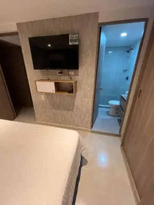 a bedroom with a bed and a bathroom with a toilet at Manglar - Ciudad Mallorquin in Puerto Colombia