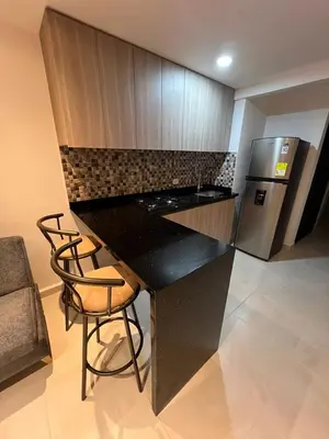 a kitchen with a black counter and a refrigerator at Manglar - Ciudad Mallorquin in Puerto Colombia