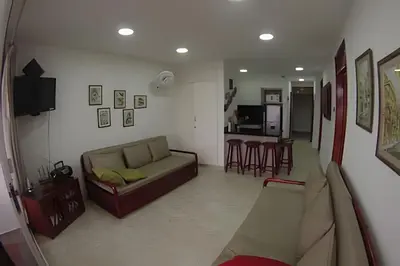 a living room with a couch and a kitchen at Hermoso apartamento con vista en el laguito in Cartagena de Indias