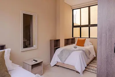 a bedroom with two beds and a window at Casa Maguey – Refugio Tropical en el Centro de Cartagena in Cartagena de Indias