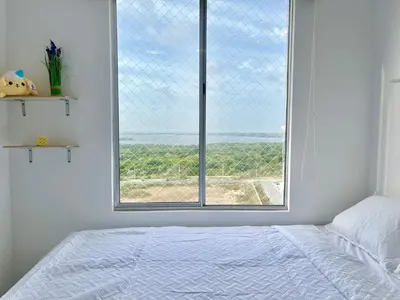 a bedroom with a bed and a large window at Relax with a views, massage chairs and coffee station in Barranquilla