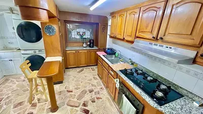 a kitchen with wooden cabinets and a stove top oven at Apto luxury en el laguito edificio marina del rey cartagena frente al mar in Cartagena de Indias