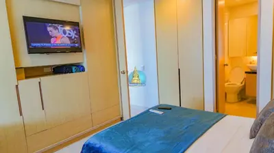 a small room with a bed and a flat screen tv at Apto Vista Laguito y Mar Piso 21 in Cartagena de Indias