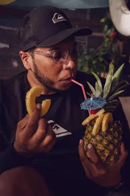 a man eating a banana and a pineapple with a straw at CARDUMEN Arte y Cocina in Playa Blanca