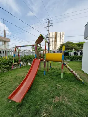 a playground with a slide in the grass at Alojamiento Nuevo en Piso 24 con WiFi Rápido y Vista al Mar, Cerca al Centro Histórico in Cartagena de Indias