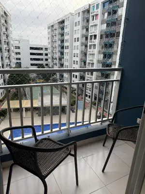 a balcony with two chairs and some buildings at Hermoso apartamento en Miramar in Barranquilla