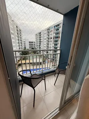a balcony with two chairs and a view of buildings at Hermoso apartamento en Miramar in Barranquilla