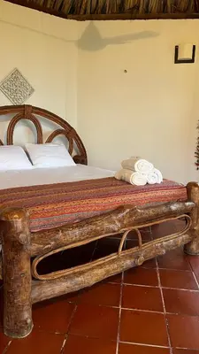 a bed with a wooden frame in a room at Punta Manzanillo in San Bernardo del Viento
