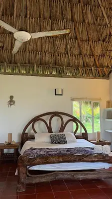 a bedroom with a large bed with a wooden headboard at Punta Manzanillo in San Bernardo del Viento