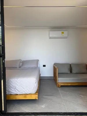 a room with two beds and a couch at Luxury Suite frente de Mar Piscina Restaurante y Bar in San Silvestre