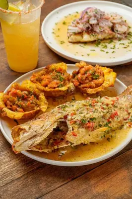 a table with two plates of food and a glass of orange juice at Luxury Suite frente de Mar Piscina Restaurante y Bar in San Silvestre