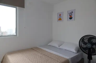a white bedroom with a bed and a window at Piso 32 Vista al mar y centro histórico in Cartagena de Indias