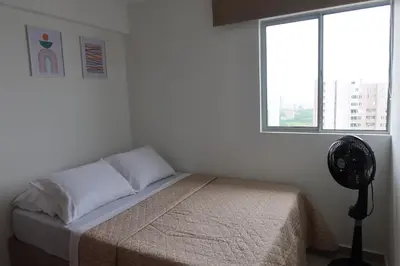 a bedroom with a bed with a fan and a window at Piso 32 Vista al mar y centro histórico in Cartagena de Indias