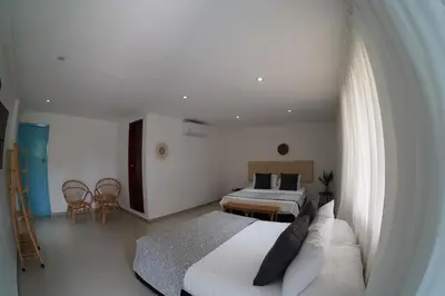 a bedroom with a couch and two beds in a room at Dorado Beach Isla in Playa Punta Arena