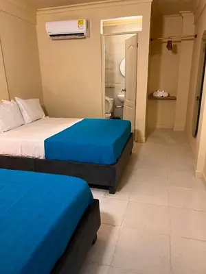 a hotel room with two beds and a bathroom at Alma Del Mar in Cartagena de Indias