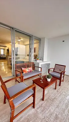 a living room with chairs and tables and a bedroom at Sunset Loft frente al mar CB1506 in Cartagena de Indias