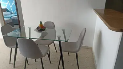 a glass table with four chairs and a cake on it at apto cartagena con vista al mar 11 in Cartagena de Indias