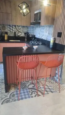 a kitchen with two red chairs and a counter at Barranquilla Dreams in Puerto Colombia