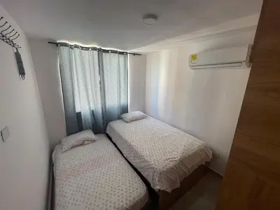 two beds in a small room with a window at Sky View Apartment en Barranquilla in Barranquilla