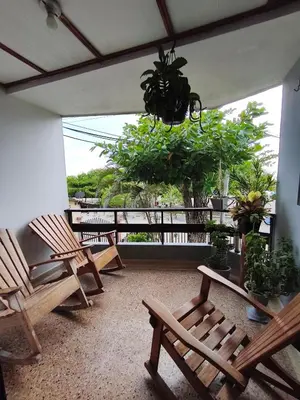 a porch with chairs and a chandelier and trees at Habitacion frente al mar en Tolú in Santiago