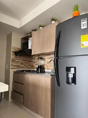 a kitchen with a stainless steel refrigerator and wooden cabinets at Villas del mar in Cartagena de Indias