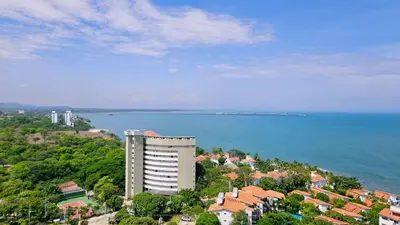 a tall building next to a large body of water at Caribbean Refuge - Beach and Pool Access 10th Floor in Santa Marta