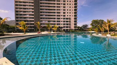 a large swimming pool in front of a tall building at Caribbean Refuge - Beach and Pool Access 10th Floor in Santa Marta