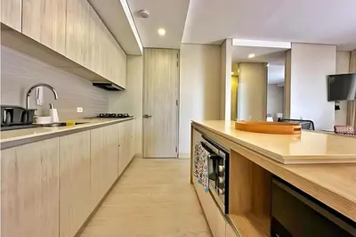 a kitchen with wooden cabinets and a counter top at Modern Apartment Cielo Mar Terrace-Pool-Jacuzzi Close to the beach in Cartagena de Indias
