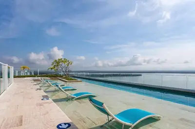 a swimming pool with chaise lounge chairs on top of a building at Modern Apartment Cielo Mar Terrace-Pool-Jacuzzi Close to the beach in Cartagena de Indias