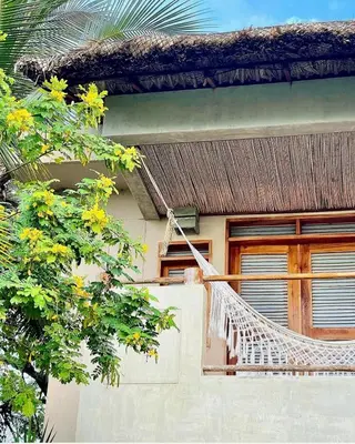 a hammock on the side of a house at En La Casa Del Mar in Moñitos