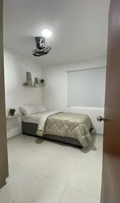 a bedroom with a bed in a white room at apartamento cerca de la playa in Cartagena de Indias
