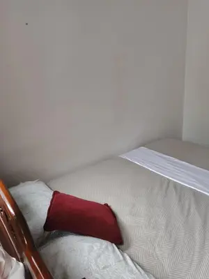 a red pillow sitting on a bed in a room at Kasa Soffi in Moñitos