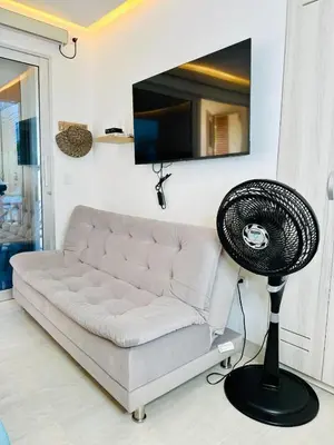 a living room with a white couch and a fan at Moderno apartamento en Playas del Francés
