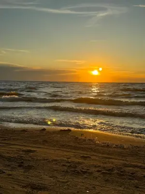 a sunset on a beach with the ocean at Moderno apartamento en Playas del Francés
