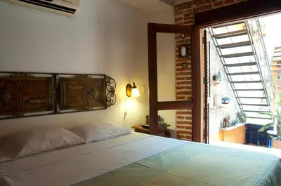 a bedroom with a bed and a window at Luxury Colonial Villa Old City Cartagena Rooftop Views Private Pool in Cartagena de Indias