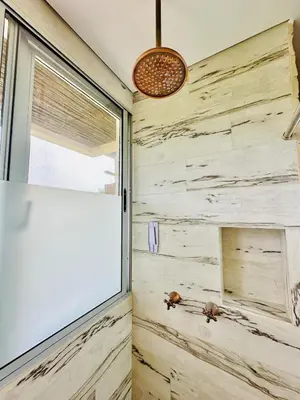 a bathroom with a stone wall and a window at Aves de Laguna Beach in Trementino
