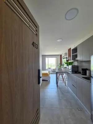 a door leading into a kitchen with a table at Modern suite steps from the sea in Santa Marta