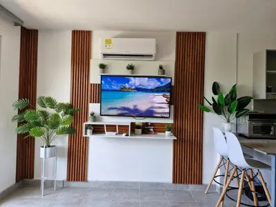 a living room with a flat screen tv on a wall at Modern suite steps from the sea in Santa Marta