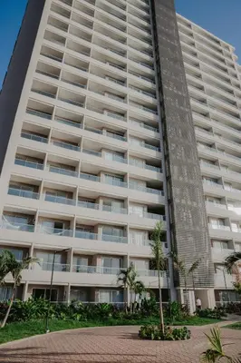 a large white building with palm trees in front of it at Coastal Comfort Retreat Beach stay Near Airport in Santa Marta