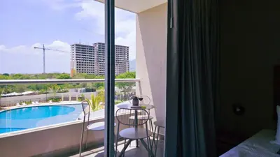 a hotel room with a balcony with a swimming pool at 1BD Luxe Shore & Balcony Sunrise Next to the Beach in Santa Marta